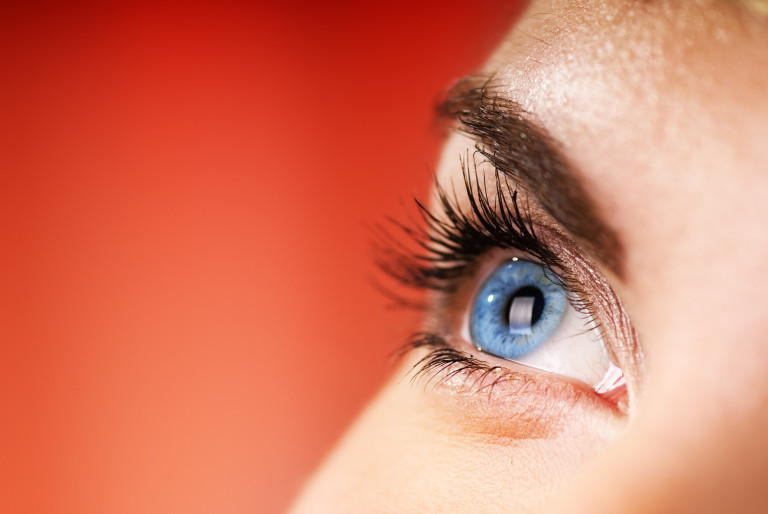 Blue eye on red background (shallow DoF)